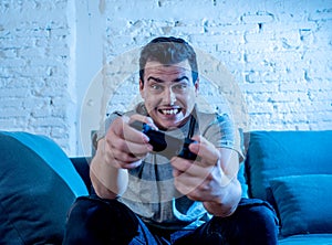 Close up portrait of young man playing video game at night addicted to it having fun