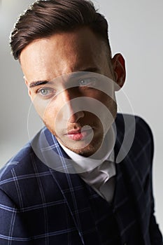 Close-up portrait of young man wearing a suit, looking away