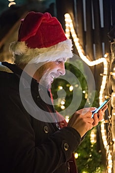 Close up portrait of young man who using smart phone, with santa