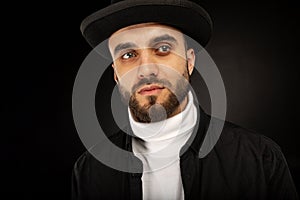 Close up portrait of young model male with beard in black hat
