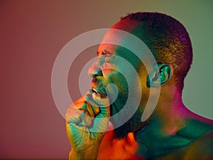 Close up portrait of a young naked african man looking at camera indoors