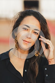 Close up portrait of young oriental brunette woman with long curly hair