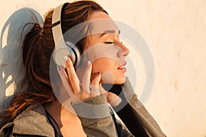 Close-up portrait of young pretty sport woman listening to music