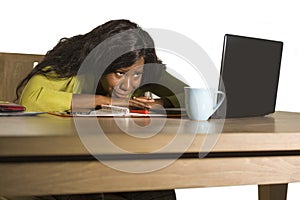 Close up portrait of young sad and depressed black afro American business woman crying while working at office computer desk feeli