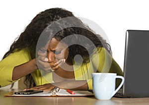 Close up portrait of young sad and depressed black afro American business woman crying while working at office computer desk feeli