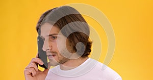 Close up portrait of young sad man talking on cellphone, shouting at phone, listening to answer