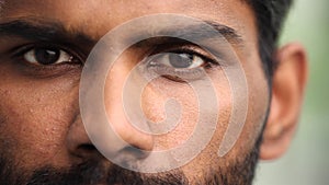 Close up portrait of a young serious man looking at the camera. He is open and serious.