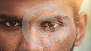 Close up portrait of a young serious man looking at the camera. He is open and serious.