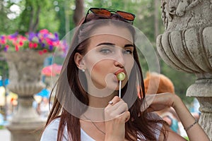 A close-up portrait of young sexual woman with lollipop