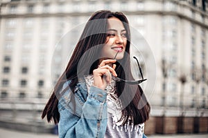 Close-up portrait of a young sexy brunette hipster girl. dressed in a stylish large denim jacket. happy young woman