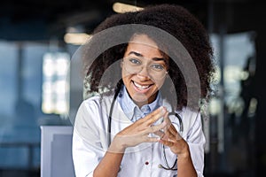 Close-up portrait of a young smiling woman doctor, nurse, student wearing a white coat, is in the hospital, with her