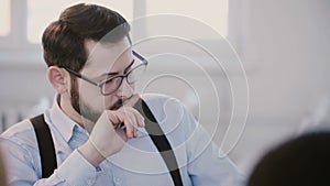 Close-up portrait of young successful serious businessman having coffee, thinking at modern workplace office meeting.