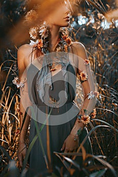 Close up portrait of young and tender woman on a feild at sunset
