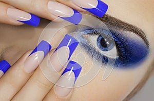 Close up portrait of young woman with big blue eyes and prefect manicure.