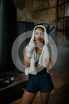 Close-up portrait of young woman boxer wrapped in towel