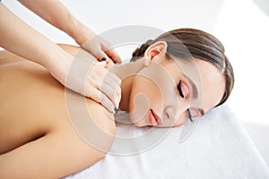 Close up portrait of young woman enjoying relaxing back massage at spa salon.