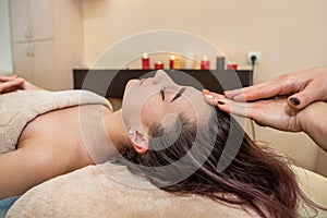 Close up portrait of young woman having head massage at spa.