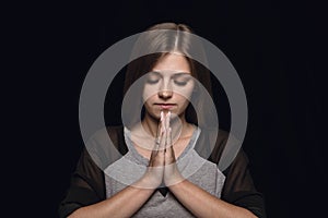 Close up portrait of young woman isolated on black studio background