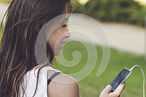 Close-up portrait of young woman listening to the music on the phone