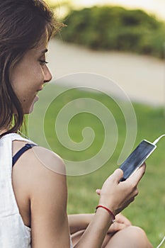 Close-up portrait of young woman listening to the music on the phone