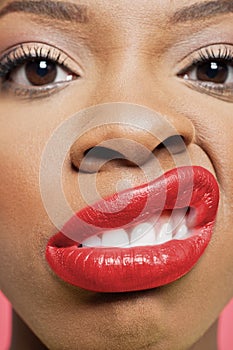 Close-up portrait of young woman with red lips grimacing