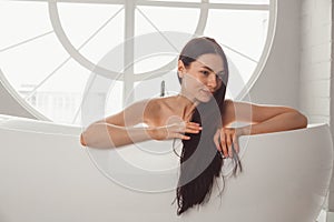 Close-up portrait of a young woman relaxing in the bathtub