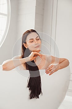 Close-up portrait of a young woman relaxing in the bathtub