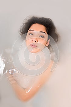 Close up portrait of a young woman relaxing in the white water,