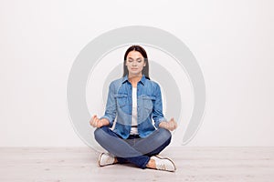 Close up portraitt of calm silent tranquile meditative lady with sign symbol om sitting in lotus position on the floor on