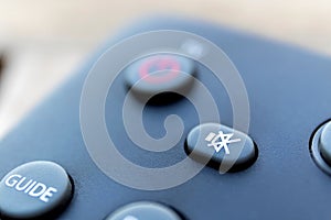 A close up portrarit of a mute button on a remote control of a surround system, dvd or blu-ray player or a television remote