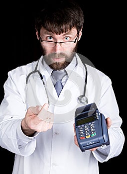Close-up portret of a Doctor holding pos-terminal, stethoscope around his neck. He rubs his thumb and forefinger