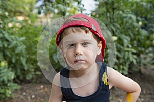 Close up portret of little beautiful boy in a red cap