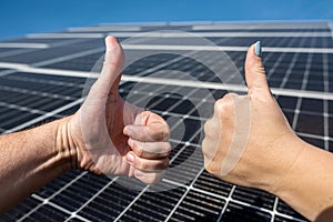 close up posing with positive gesture on photovoltaic solar panel and thumbs up.