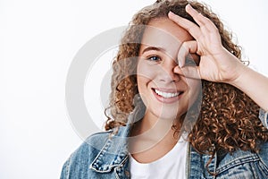 Close-up positive charismatic lively young confident plump curly-haired woman show okay ok perfect gesture eye look