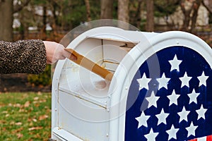 Close-up Of Postman Putting Letters Mailbox American flag photo