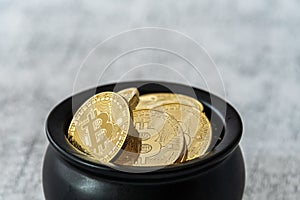 Close up of pot of gold bitcoins on a white and gray crackle background