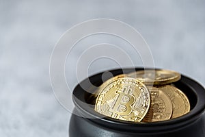Close up of pot of gold bitcoins on a white and gray crackle background
