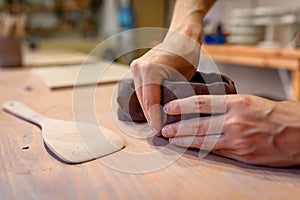 Close up of potter hands working with clay and ceramic tools, craftsman hands. knead and moistens the clay before work in ceramic