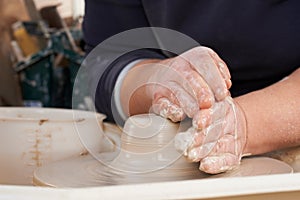 Close Up Of Potter Moulding Clay On Wheel