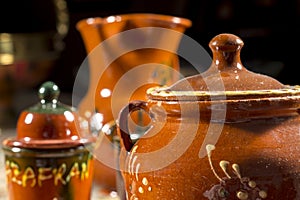 Close-up of pottery sugar bowl in front of other jars