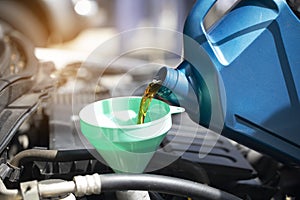 Close up of Pouring fresh oil to car engine in auto repair service, Change oil