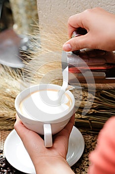 Close up pouring milk into coffee making hot latte - Soft focus