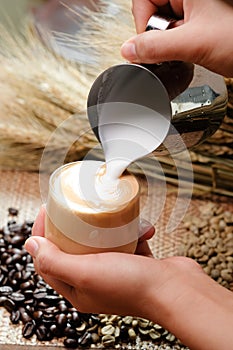 Close up pouring milk into coffee making hot latte - Soft focus