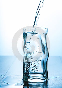 Close up pouring purified fresh drink water from the bottle in glass