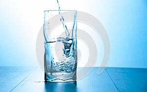 Close up pouring purified fresh drink water from the bottle in glass