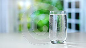 Close-up pouring purified fresh drink water from the pitcher on table in kitchen