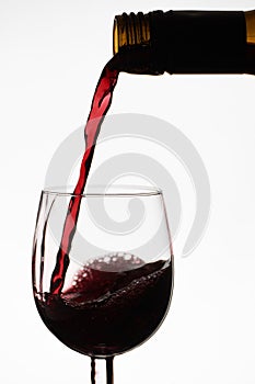 Close up of pouring of red dry wine in a crystal wine glass