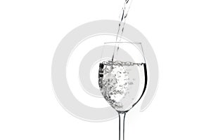 Close up pouring water in the glass isolated on white background. Water pour in to the glass