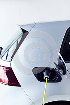 Pohled zblízka na napájecí kabel nabíjení ekologicky přátelský nula emise elektrický auto v garáž 