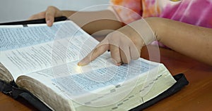 Close-up of Prayer hand pointing to the Bible Spiritual book, concepts by studying the Holy Scriptures